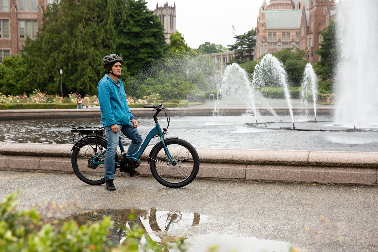 services-05 A man with an electric bike enjoys Seattle's scenic park and fountain view.